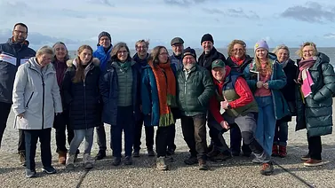 Gruppenbild mit 20 Personen vor blauem Himmel